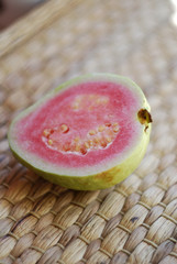 Fototapeta na wymiar Half of pink guava isolated on a rattan mat.