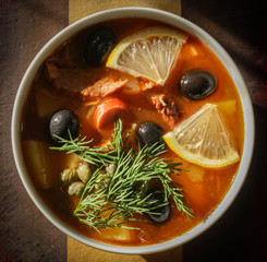 Traditional Russian soup solyanka closeup in a bowl on the table.