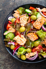Salad with fish. Fresh vegetable salad with salmon fish fillet. Fish salad with salmon fillet and fresh vegetables on plate