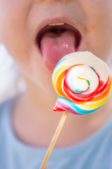 Little kid, child with colorful lolipop