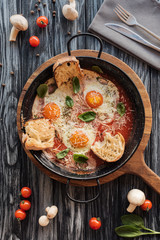 top view of gourmet roasted eggs with cheese and fresh vegetables