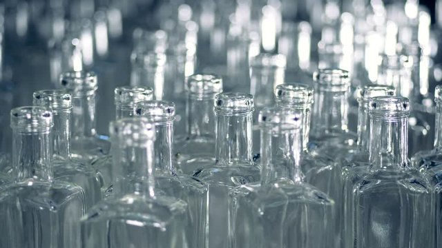 A pile of empty glass bottles is moving forwards and sideways
