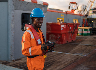 Seaman AB or Bosun on deck of offshore vessel or ship , wearing PPE personal protective equipment -...