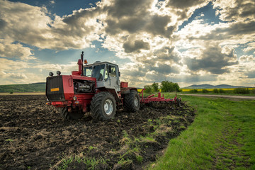 Fototapeta premium Tractor plowing fields.