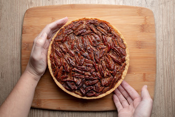 Woman holding homemade baked gourmet pecan pie