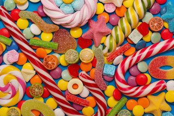 Multicolored candy and lollipops on a white background.