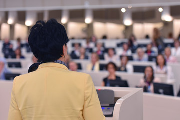 Fototapeta premium Business woman as leader speaking at Conference. Audience at the conference room or hall , representing model of economic development and startup business and interreligious relations