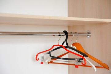 Colorful clothes hangers in an empty wardrobe. Empty wardrobe like symbol of divorce or poverty