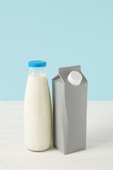  milk in bottle and blank carton package on blue background