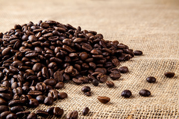 Pile of roasted coffee beans on a hessain cloth