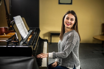 A pianist pays a piano in the camera and laughs