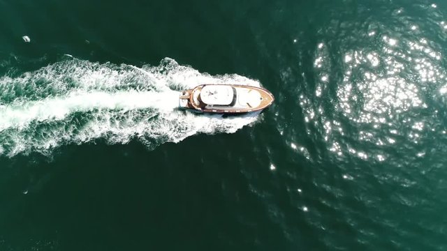 Aerial flight towards luxurious cabin cruiser motorboat also known as speedboat or powerboat is vessel which is powered by an engine beautiful summer day showing blue tropical water and reflection 4k