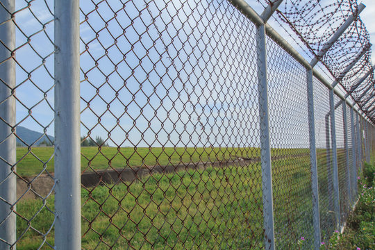 Chain link fence with grass field Phuket International Airport