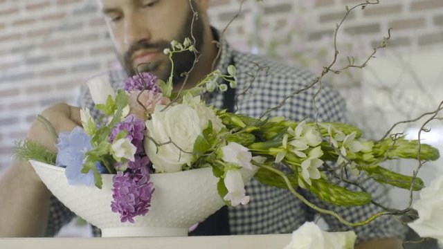 Close up hands of florist man making wedding decoration at flower shop
