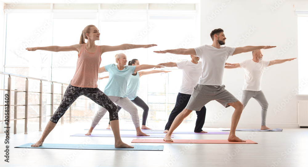 Poster Group of people in sportswear practicing yoga indoors