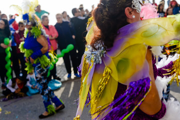 Blurry street carnival party parade unrecognisable people dressed for joyful fun, outdoors background