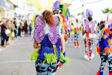 Blurry street carnival party parade unrecognisable people dressed for joyful fun, outdoors background