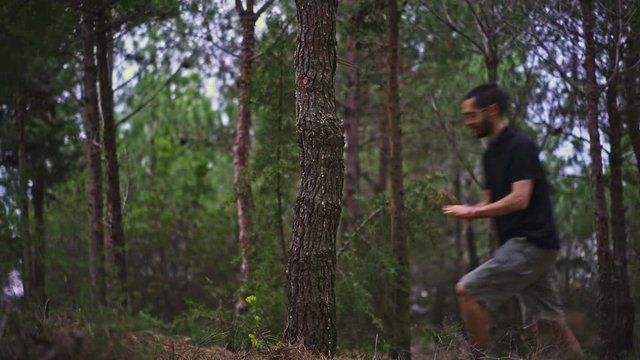 Funny Young Man magically pulls himself out of a tree in the forest, and then back in