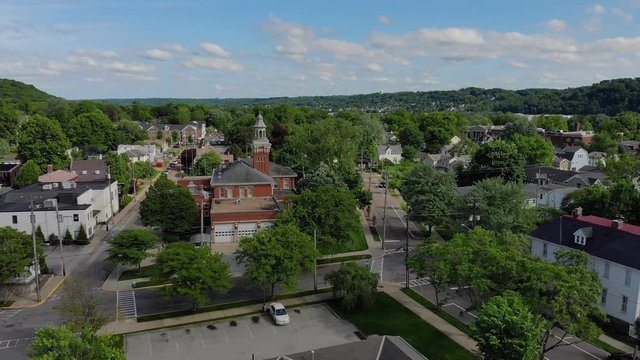 A slow moving forward wide aerial establishing shot of the steeple of a city hall in the small New England town. Pittsburgh suburbs.  	