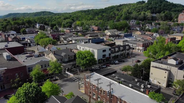 SEWICKELY, PA - Circa May, 2018 - A daytime backward moving wide aerial establishing shot of a small town's business district on a sunny summer day. Pittsburgh suburbs.  	
