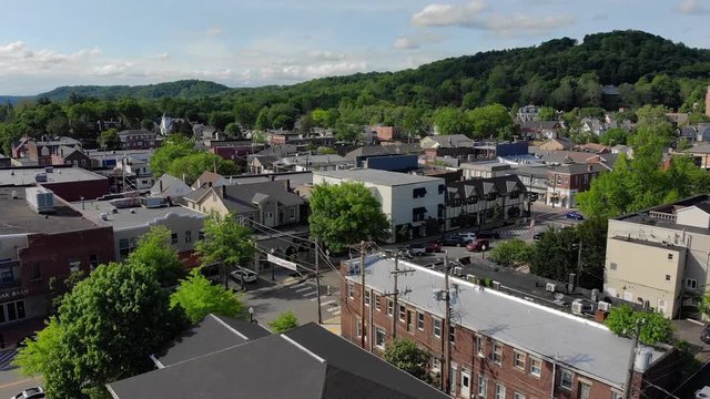 SEWICKELY, PA - Circa May, 2018 - A daytime slow rising aerial reveal of a small town's business district. Pittsburgh suburbs.  	