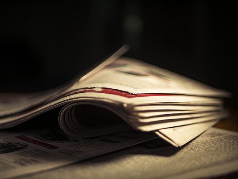 Close Up Wrinkled Newspaper On The Table In The Dark Room