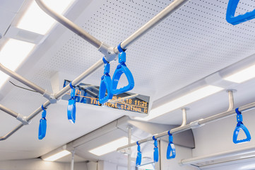 Blue hanging handholds for standing passengers in a modern train