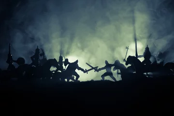 Fotobehang Medieval battle scene with cavalry and infantry. Silhouettes of figures as separate objects, fight between warriors on dark toned foggy background. Night scene. © zef art