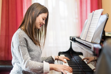 A young woman plays a piano