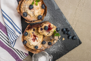 Blueberry muffins with powdered sugar and fresh berries