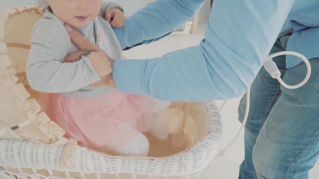 Young Dad carefully look at the his child who sit in the stroller. Slow motion. Baby milestone, toddler, 1 year old. Happy childhood