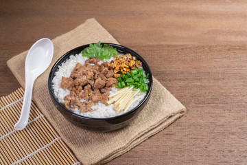 boiled rice with pork and vegetable in a ceramic bowl on wooden table. homemade style food concept.