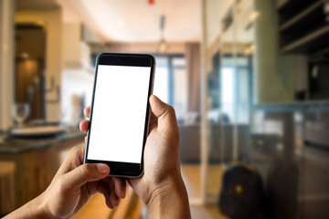 A man hand holding smart phone device in the bright office room interior.