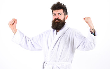 Health and fitness concept. Bearded guy in bathrobe showing muscles over white background. Full of energy man in the morning