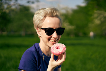 woman with a pink donut in nature
