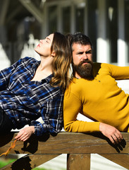 Girl and bearded guy lie on handrail back to back