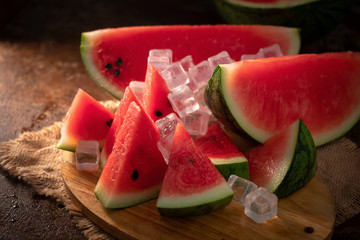 watermelon and watermelon pieces in a wooden background