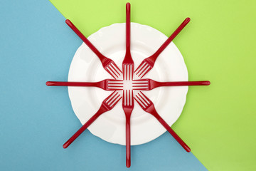 Still Life with plastic forks and a plate on a color background, for decoration, for text design, for template