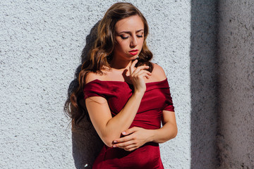 Beautiful young woman in a long red evening gown with a train