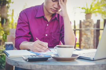 Overworked young man having headache after hard working day.