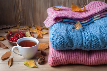 autumn clothes on a wooden background, sweaters, knitwear, wool.