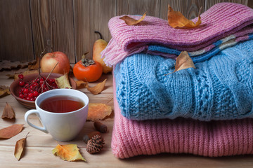 autumn clothes on a wooden background, sweaters, knitwear, wool.