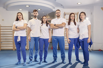 large team, group of physical therapists  workers posing, work room indoors. - obrazy, fototapety, plakaty