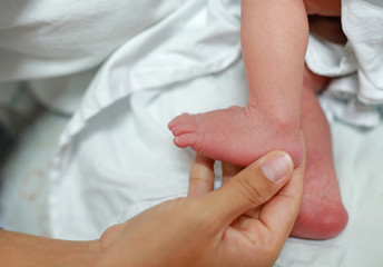 Close up mother hand holding newborn baby feet.