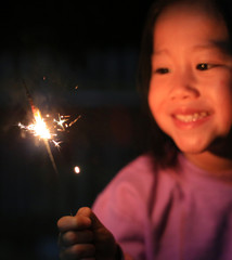 Little Asian child girl enjoy playing firecrackers.