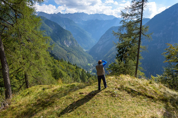 Fototapeta na wymiar A Hiker taking picture of Mountain View from Vrsic pass, Julian Alps, Slovenia