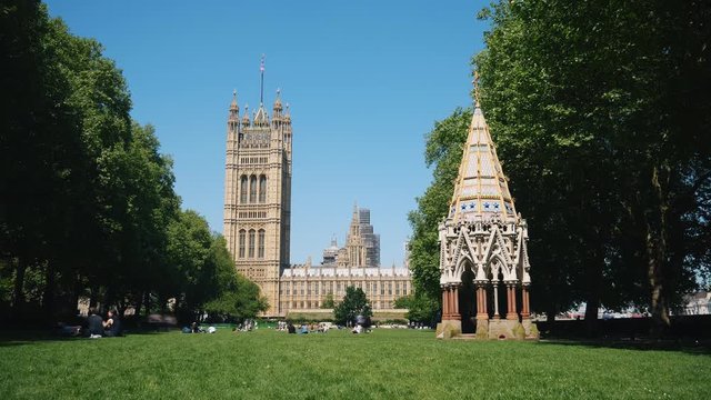 Time lapse. People sunbathing in the park by the Westminster Palace. London.