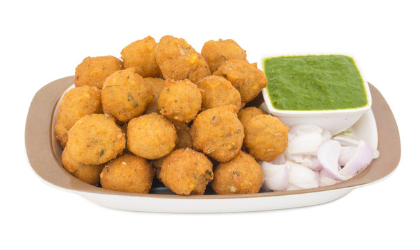 Indian Spicy Street Food Dal Vada Also Know as Moong Dal Vada, Pakoda, Pakode, Pakore, Moong Vada, Pakora or Bhajiya Served with Green Chutney or Onion isolated on White Background