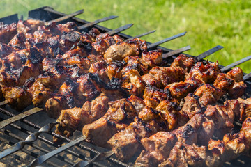 Shashlik preparing on a barbecue grill over charcoal. Shashlik or Shish kebab popular in Eastern Europe.