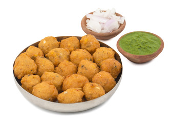 Indian Spicy Street Food Dal Vada Also Know as Moong Dal Vada, Pakoda, Pakode, Pakore, Moong Vada, Pakora or Bhajiya Served with Green Chutney or Onion isolated on White Background